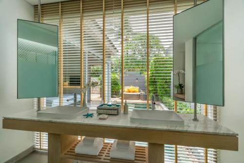 łazienka z 2 umywalkami i dużym oknem w obiekcie Avani Plus Samui Resort w mieście Taling Ngam Beach