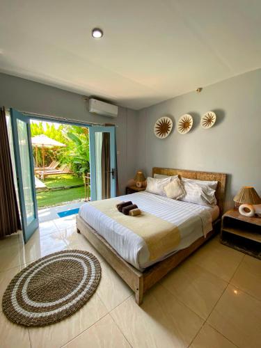 a bedroom with a large bed and a large window at Gatsby Hotel Hostel in Uluwatu