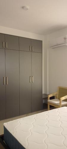 a bedroom with a bed and some cabinets at Lee's Mombasa Havenstays in Kanga