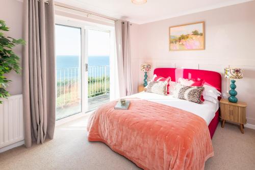 a bedroom with a large bed and a large window at NEW Luxury Beachfront House sleeps 8 Exmouth Devon in Exmouth