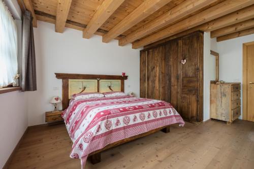 a bedroom with a bed and a wooden ceiling at Antico Fienile in Borca di Cadore