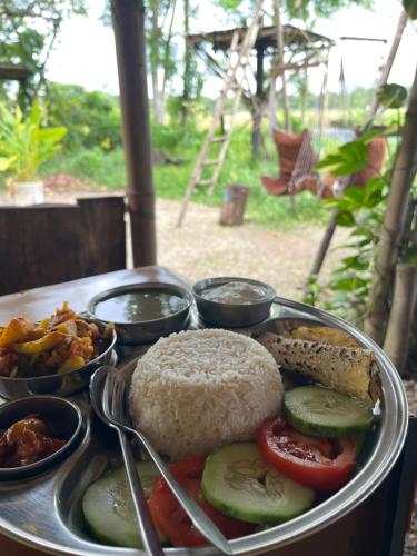 a tray of food with rice and vegetables on a table at Pemsee's Tree Town - Eco-friendly,Tree house hostel in Sauraha