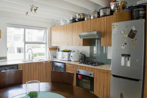 a kitchen with a refrigerator and a table in it at Serene escape in Johannesburg in Fourways