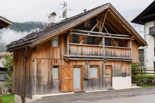 a wooden building with a cross on the roof at Antico Fienile in Borca di Cadore