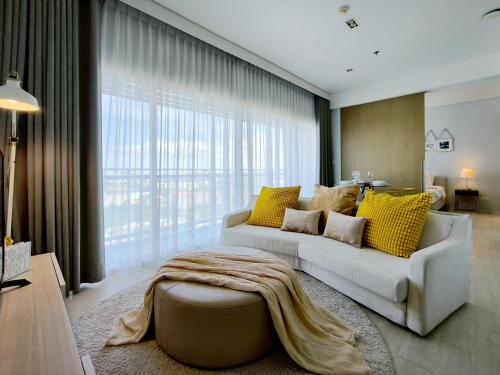 a living room with a white couch and yellow pillows at 2 Bedroom Condo R258 Veranda Pattaya Beachfront in Na Jomtien