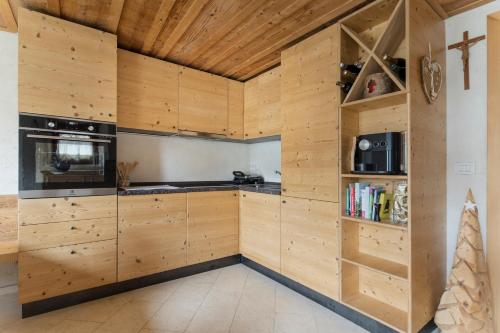 a kitchen with wooden walls and wooden cabinets at Antico Fienile in Borca di Cadore