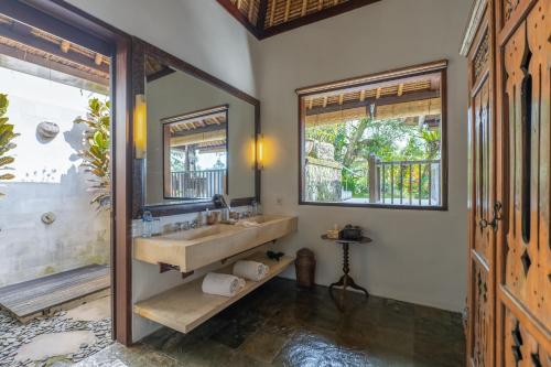 a bathroom with a sink and a mirror at Villa Bayad in Payangan