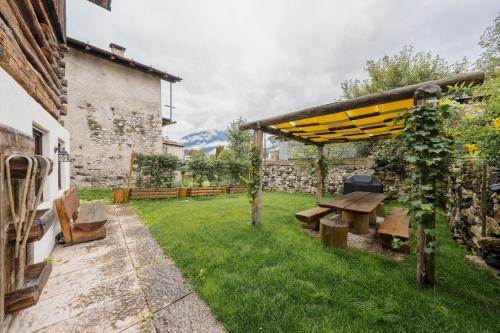 a picnic table in a garden next to a building at Antico Fienile in Borca di Cadore