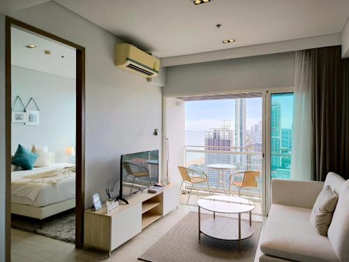 a bedroom with a bed and a living room with a view at 2 Bedroom Condo R315 Veranda Pattaya Beachfront in Na Jomtien