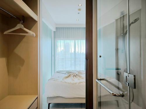 a bedroom with a bed and a glass shower at 2 Bedroom Condo R315 Veranda Pattaya Beachfront in Na Jomtien