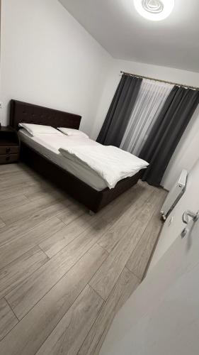 a bedroom with a bed and a wooden floor at City Place Luxury in Târgovişte