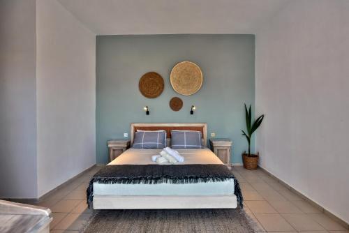 a bedroom with a large bed with blue walls at Naiades Hotel by Estia in Kato Gouves