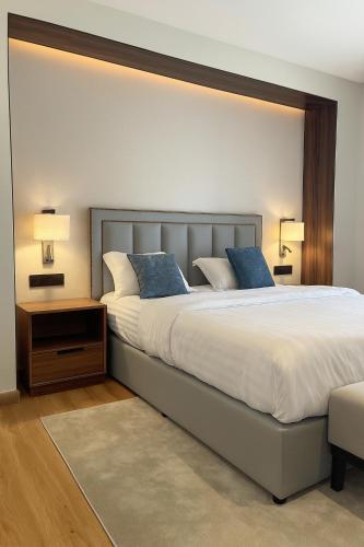 a bedroom with a large bed with two blue pillows at Unique Suites in Riyadh