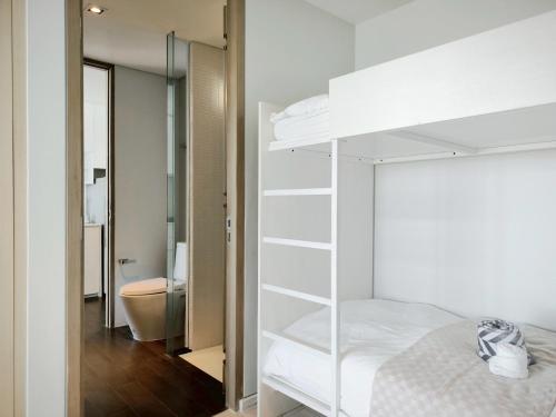 a bedroom with a white bunk bed and a bathroom at 2 Bedroom Condo R268 Veranda Pattaya Beachfront in Na Jomtien