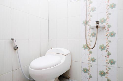 a bathroom with a toilet and a shower at Urbanview Hotel Griya Surya Malang by RedDoorz in Malang