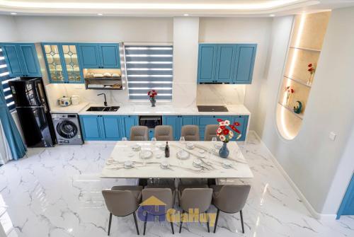 Una cocina con gabinetes azules y una mesa y sillas. en Biệt thự nghỉ dưỡng Phan Thiết, en Phan Thiet