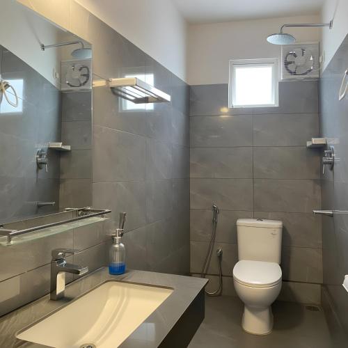 a bathroom with a toilet and a sink at Lotus Luxury Stays in Nanu Oya