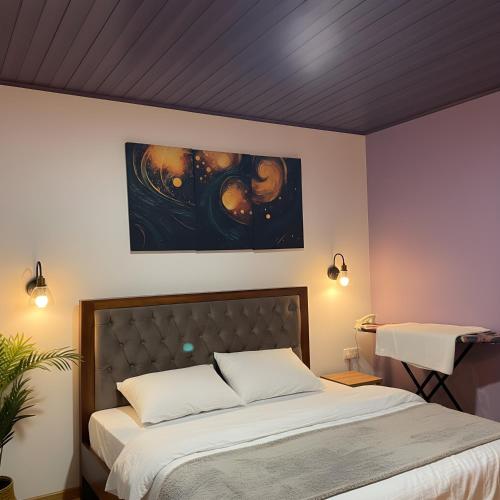 a bedroom with a bed and a painting on the wall at Lotus Luxury Stays in Nanu Oya