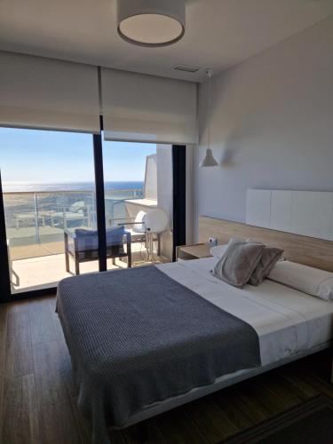 a bedroom with a large bed and a balcony at Apartment Sunset Cliffs Poniente in Benidorm