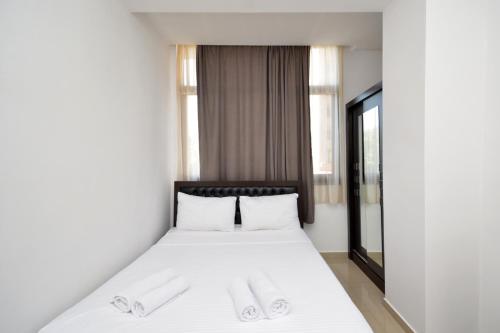 a bedroom with a bed with white sheets and white pillows at Stylish 3 room ap near republic square in Yerevan