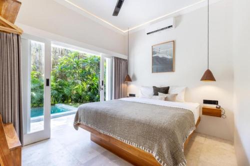 a bedroom with a bed and a large window at Villa Dua Nomada in Kuta Lombok