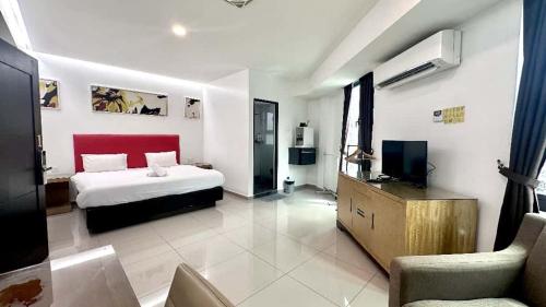 ein Hotelzimmer mit einem Bett und einem Fernseher in der Unterkunft Jovial Boutique Hotel```` Kampung Baru in Bukit Mertajam