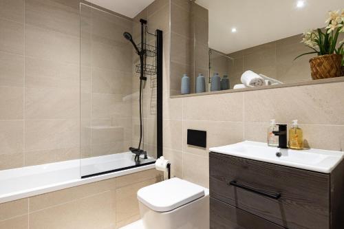 a bathroom with a toilet and a sink and a bath tub at Rock Mill 2 Bed Apartment 22 in Stoney Middleton