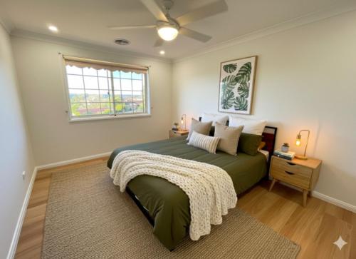 a bedroom with a green bed and a window at Sunny Lakeview Lodge- Perfect for Family & Friends in Bonnells Bay