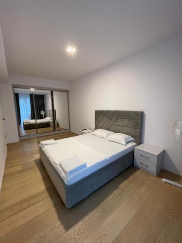 a bedroom with a large bed and a living room at London Residence Deluxe 2-Bedroom in Suceava