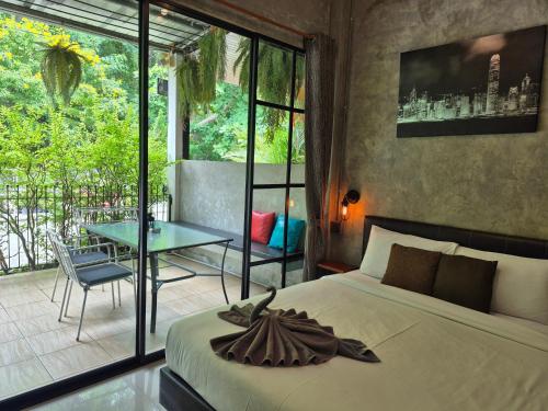 a bedroom with a bed and a patio with a table at Samed Your House in Ko Samed