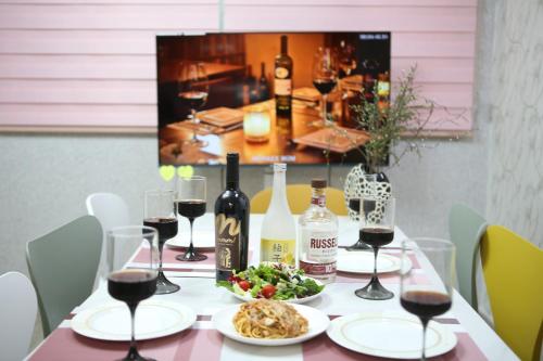 a table with glasses of wine and food on it at Daegu Room new open 4 RoomPrivate Villa in Daegu