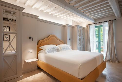 a bedroom with a large bed and a window at Terre dei Ghelfi Luxury Boutique Apartments & Spa - Adults Only in Castagneto Carducci
