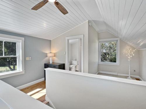 a white room with a toilet and two windows at Long Sands Home in York