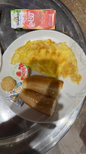 a plate of food with an omelet and a hot dog at RAFiF Pyramids View Hotel in Cairo