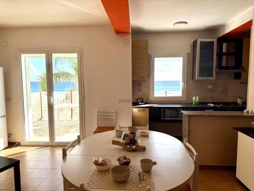 a living room with a table and a kitchen at San Lorenzo Beach in Marina di San Lorenzo