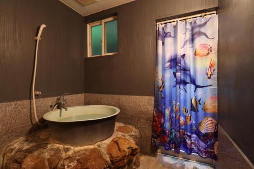 une salle de bain avec un lavabo et un rideau de douche dans l'établissement Oceanview 16 IKI, à Iki