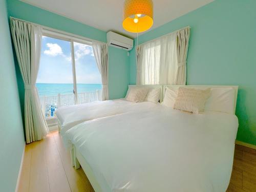 ein Schlafzimmer mit großem Bett und Blick auf das Meer in der Unterkunft The feel Kincho cho Seaside villa - sea - / Vacation STAY 26185 in Yaka