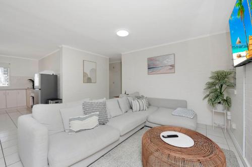 a white living room with a white couch and a table at Saltz on The Strand in North Ward