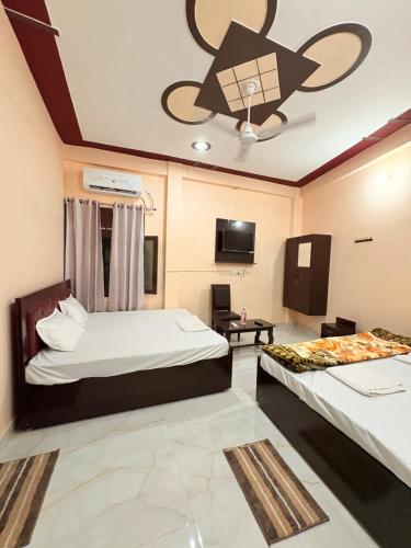 a hotel room with two beds and a ceiling fan at Shree Ramanam Palace in Ayodhya