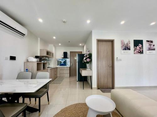 a living room with a table and a kitchen at Shi House -Cozy 2BR, S1001 Beautiful Vinhomes Q9 in Ho Chi Minh City