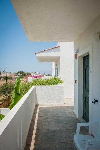 a walkway leading to a white building with a door at Ilios and Irene in Mastichari