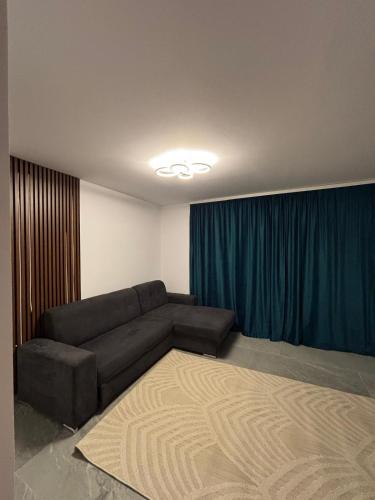 a living room with a couch and a blue curtain at Cozy Apartment Mureseni in Târgu-Mureş