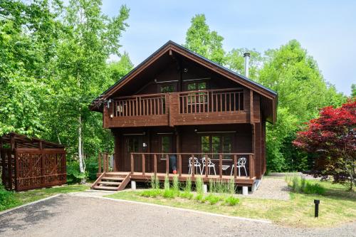 a log cabin in the woods with a driveway at The Lodge Teshikaga in Teshikaga