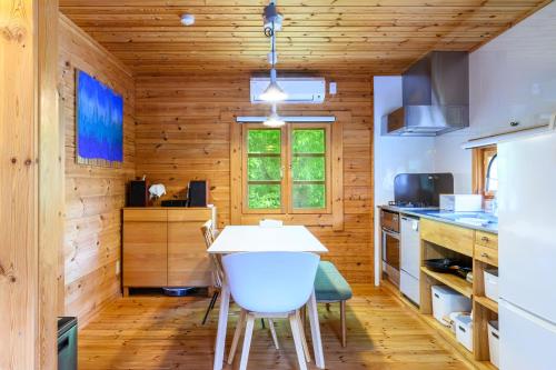 a kitchen with wooden walls and a table and chairs at The Lodge Teshikaga in Teshikaga