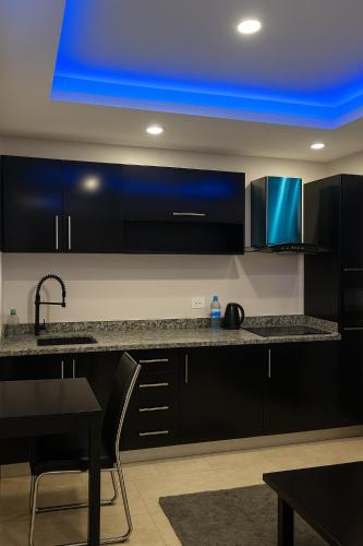 a kitchen with black cabinets and a blue ceiling at NO 95 SUITES VI in Lagos