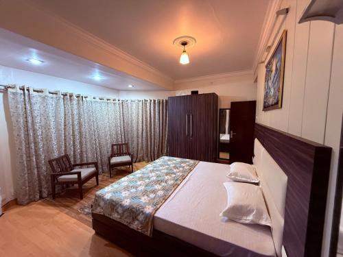 una camera da letto con un letto e una sedia di CasaCosyMussoorie-MussoorieMallRoad-Landour-Aurora a Mussoorie