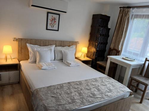 a bedroom with a bed with two lamps and a window at Perla Argesului, Ciubar, Piscina, Lift, Evenimente, Cabana, Pensiune, Hotel Cazare Transfăgarasan Curtea de Arges in Albestii de Arges