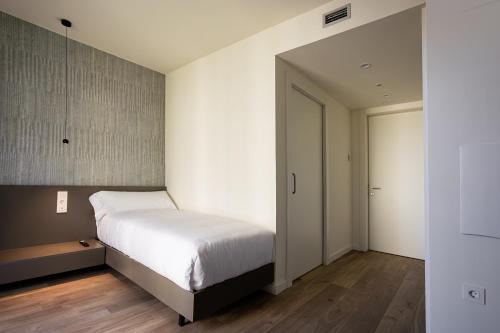 a bedroom with a large white bed and a door at Kronoguest - Auto check-in in Castañares
