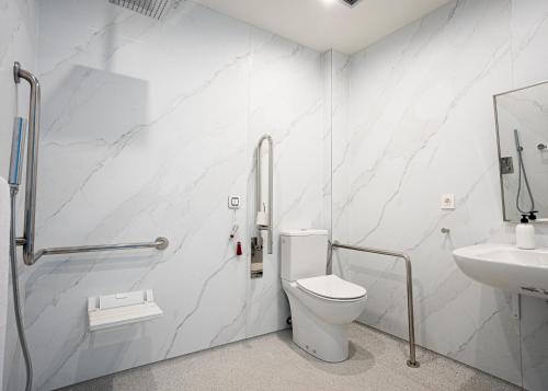a white bathroom with a toilet and a sink at Kronoguest - Auto check-in in Castañares