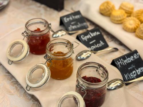 een tafel met twee potten jam en andere jam bij Schlosshotel Ahaus in Ahaus